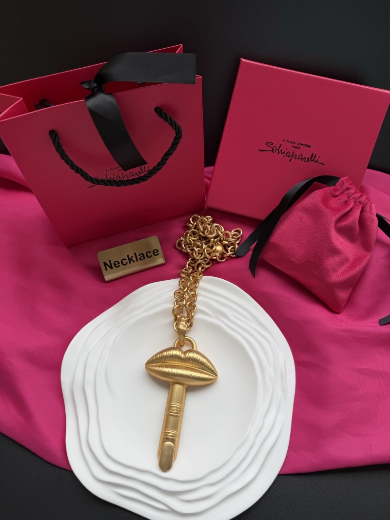 Золотистое колье с подвеской в виде губ и пальца Schiaparelli