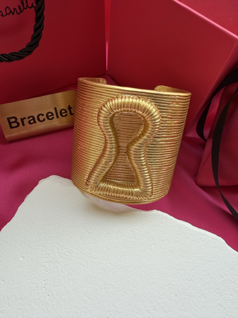 Золотистый браслет с рельефным узором Schiaparelli