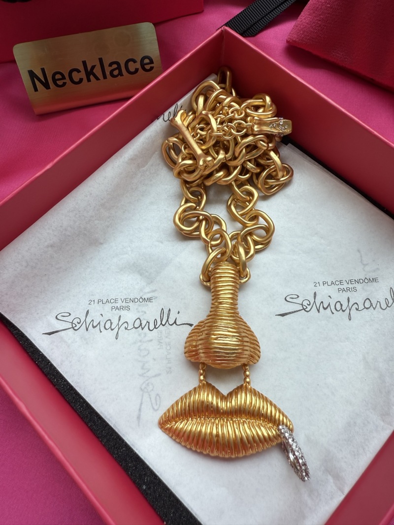 Золотистое колье с подвеской в виде губ Schiaparelli
