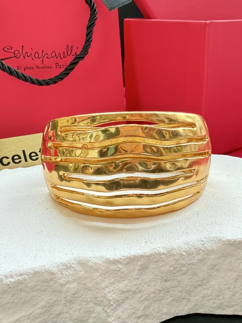 Золотистый браслет Schiaparelli