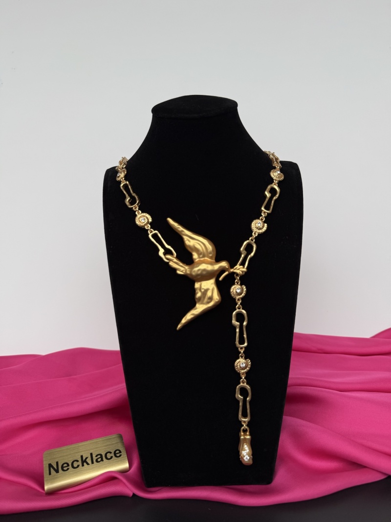 Золотистое колье с изображением птицы Schiaparelli