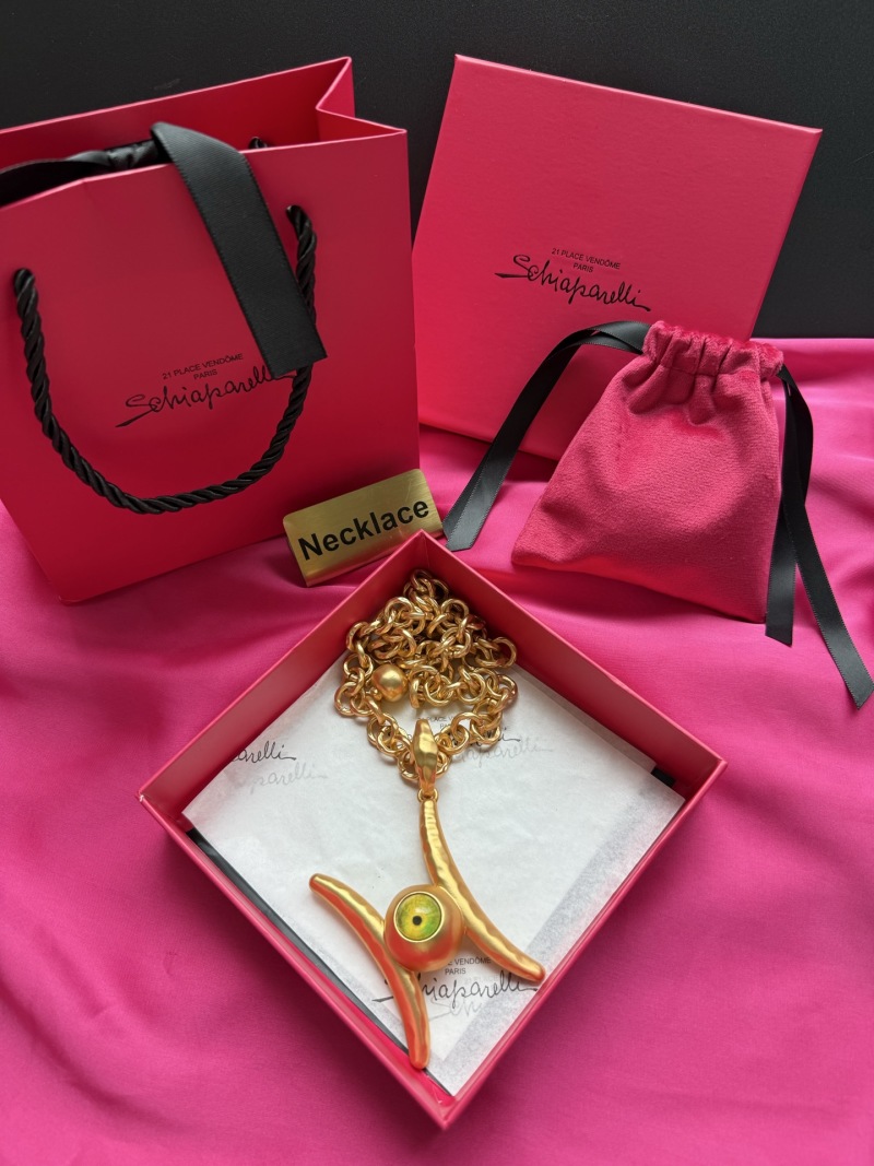 Золотистое колье с подвеской в виде глаза Schiaparelli