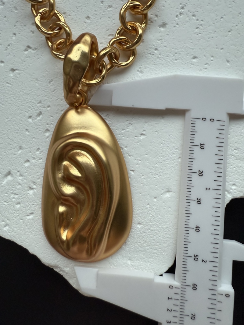 Золотистое колье с подвеской в виде уха Schiaparelli