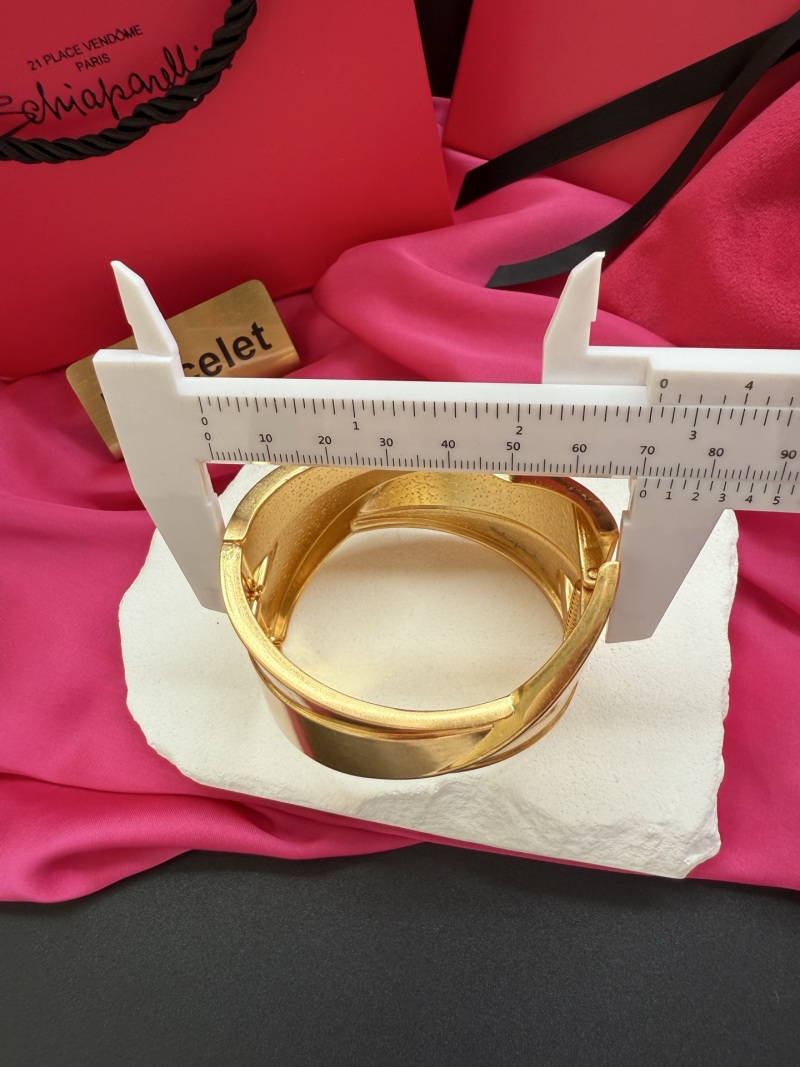 Золотистый браслет с фактурным дизайном Schiaparelli