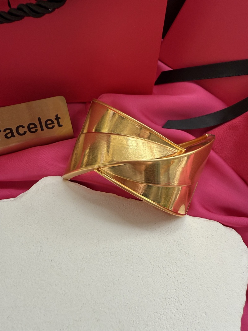 Золотистый браслет с фактурным дизайном Schiaparelli