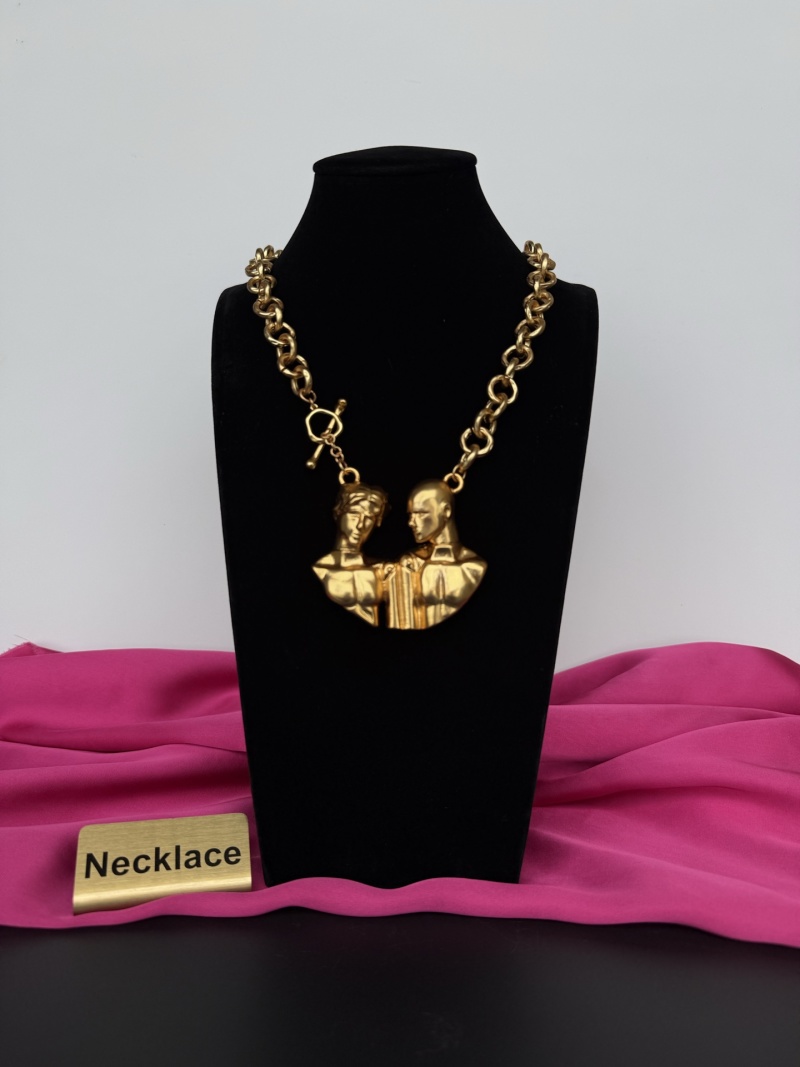 Золотистое колье с брелком в виде двух голов Schiaparelli