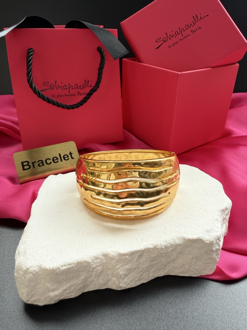 Золотистый браслет Schiaparelli