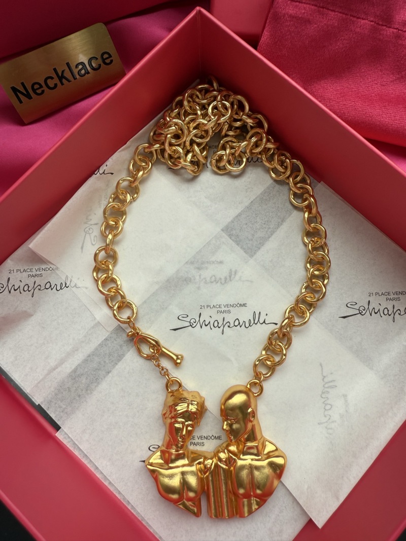 Золотистое колье с брелком в виде двух голов Schiaparelli