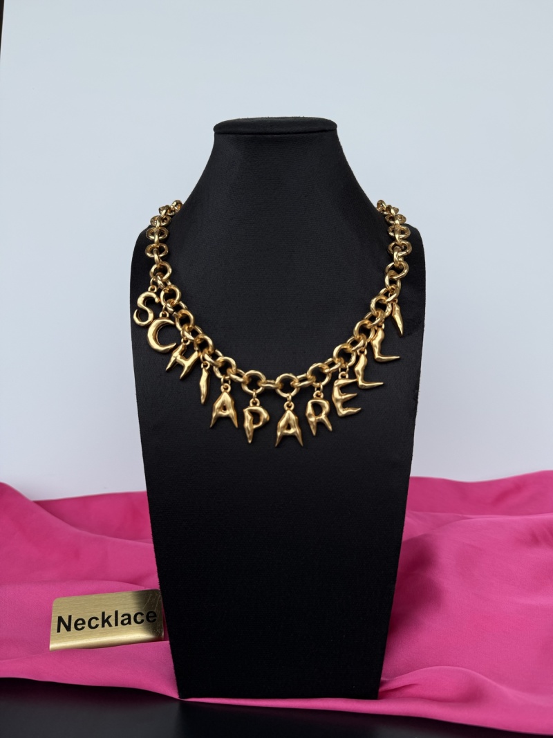 Золотистое колье с подвесками в виде букв Schiaparelli