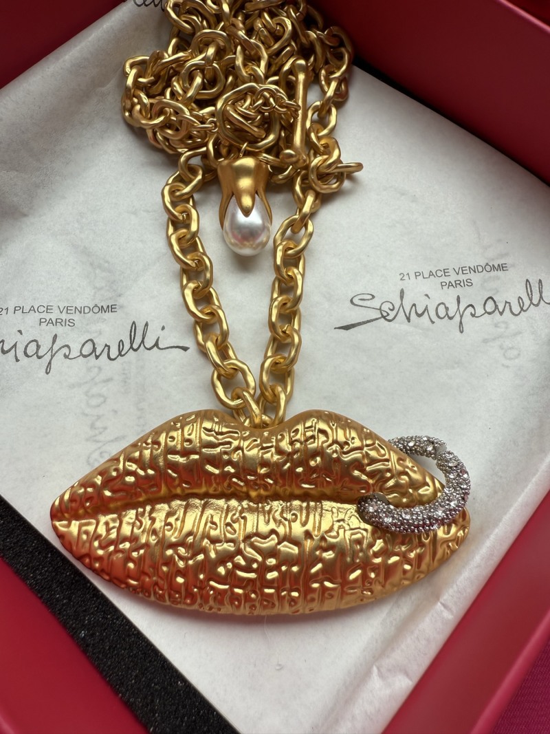 Золотистое колье с подвеской в виде губ Schiaparelli