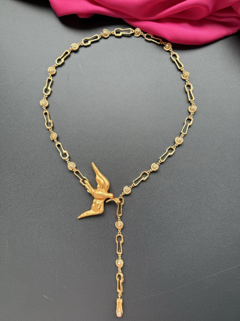 Золотистое колье с изображением птицы Schiaparelli